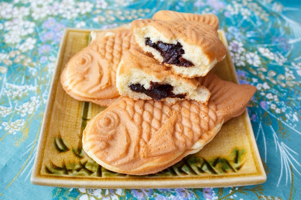 A few Taiyaki stacked on top of one another, seemingly with red bean paste inside.