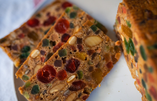 : Slices of Christmas fruit cake with dried fruits, almonds and spiced rum