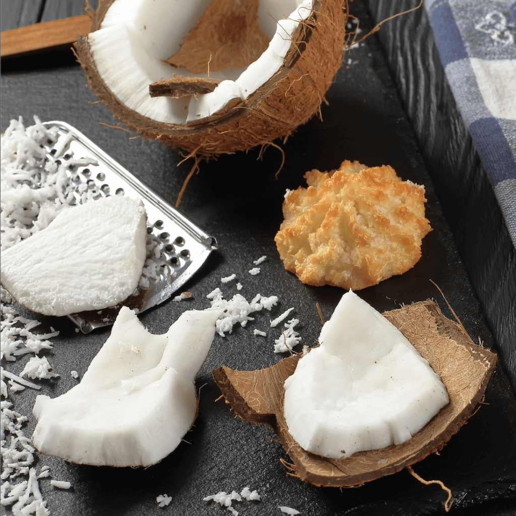 Coconut flakes surrounding coconut macaroons. Flocons de noix de coco entourant les macarons à la noix de coco.