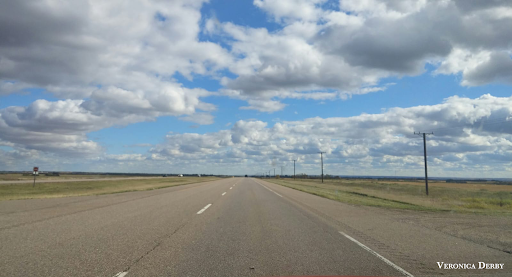 A sprawling landscape of clouds and plains in Saskatchewan. Un vaste paysage de nuages et de plaines en Saskatchewan.