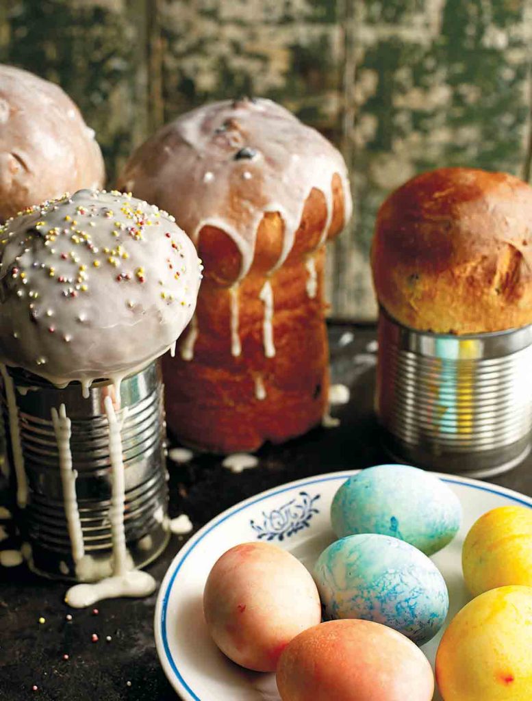 Ukrainian Babka Bread with some still in tin cans and some painted Easter eggs in the foreground. Ukrainien Babka Pain avec certains encore en boîtes de conserve et quelques œufs de Pâques peints au premier plan