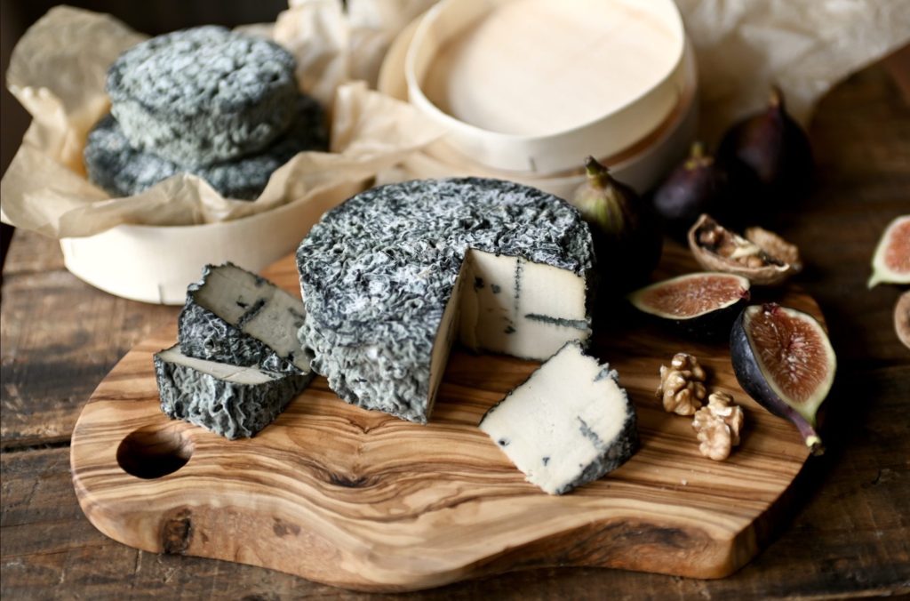 A delicious and convincing vegan blue cheese on a wooden cutting board. Un fromage bleu végétalien délicieux et convaincant sur une planche à découper en bois