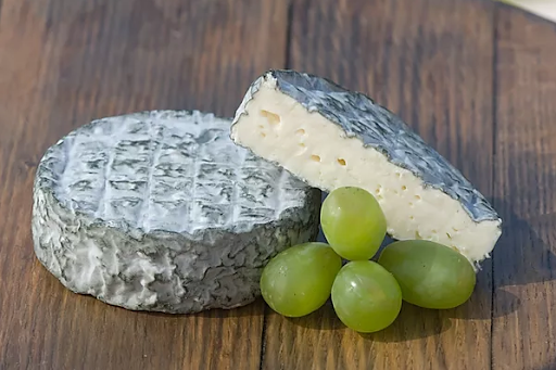 Deux blocs de fromage qui ressemblent à du camembert mais ont une croûte plus foncée.
