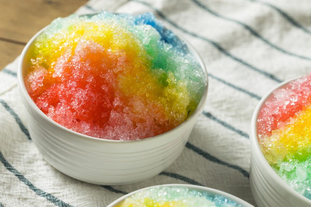 A bowl of rainbow-coloured shaved ice. Un bol de glace rasée couleur arc-en-ciel.