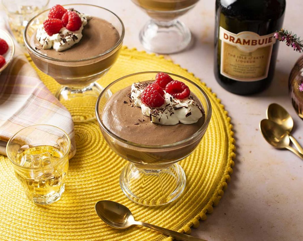 Two bowls of chocolate mousse with drambuie whiskey in the background