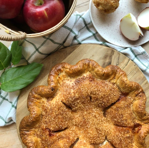 Une tarte aux pommes croustillante et délicieuse à côté de pommes fraîches.