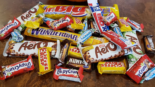 Une pile de barres de chocolat, dont wunderbar, aero, caramilk, crispy crunch, mr. big, et bounty.
