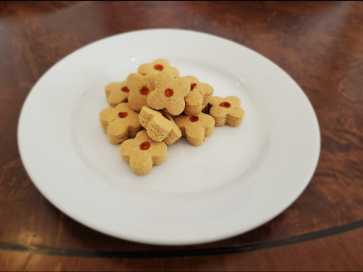 Biscuits persans Nan-e-nokhodchi en forme de fleurs sur une assiette blanche