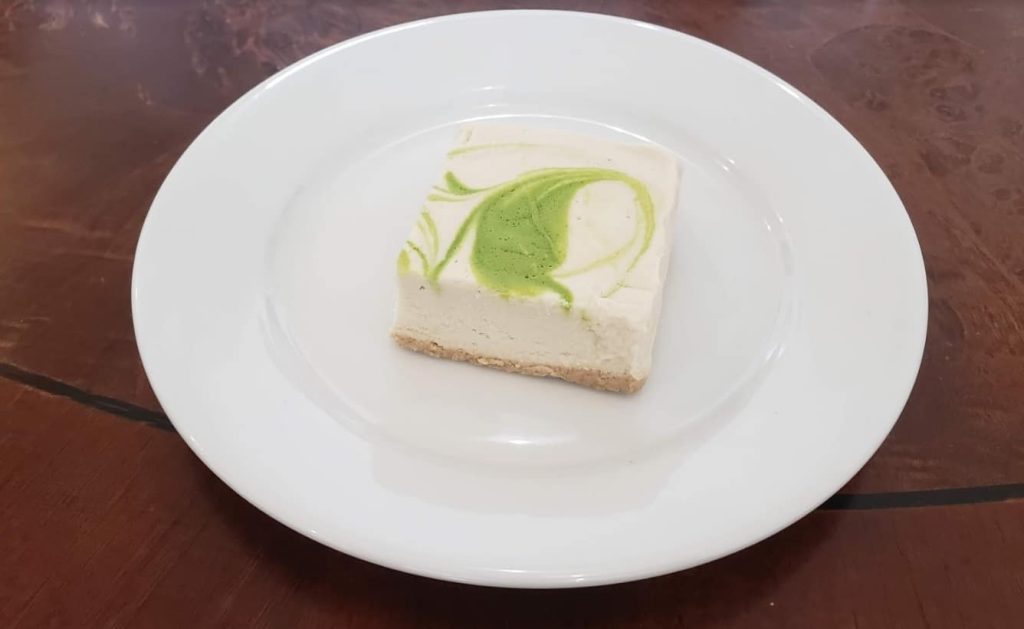 Cheezecake au citron avec un magnifique tourbillon vert sur le dessus.