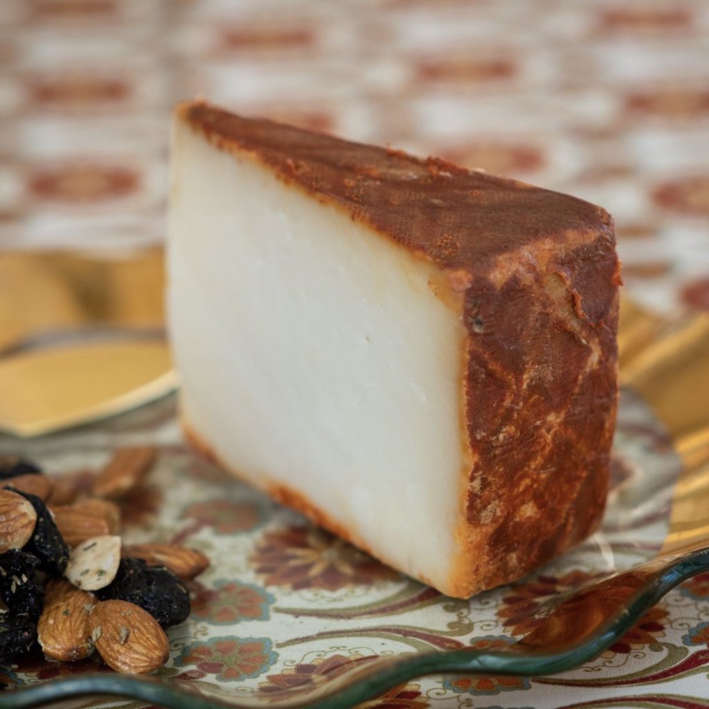 A triangular slice of Majorero cheese with burnt orange powder of chili and paprika on the exterior.