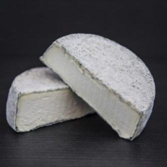 A wheel of Selle sur Chers cheese cut in half and placed aesthetically.