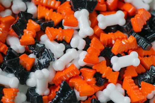 A handful of black, white, and orange bats and bones Halloween candies